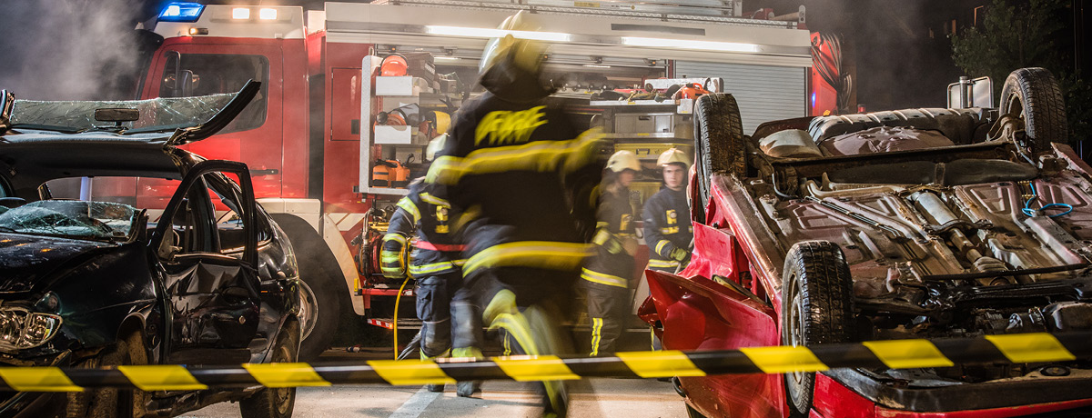 Damaged vehicles at the scene of a car accident with emergency responders