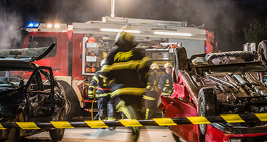 Damaged vehicles at the scene of a car accident with emergency responders