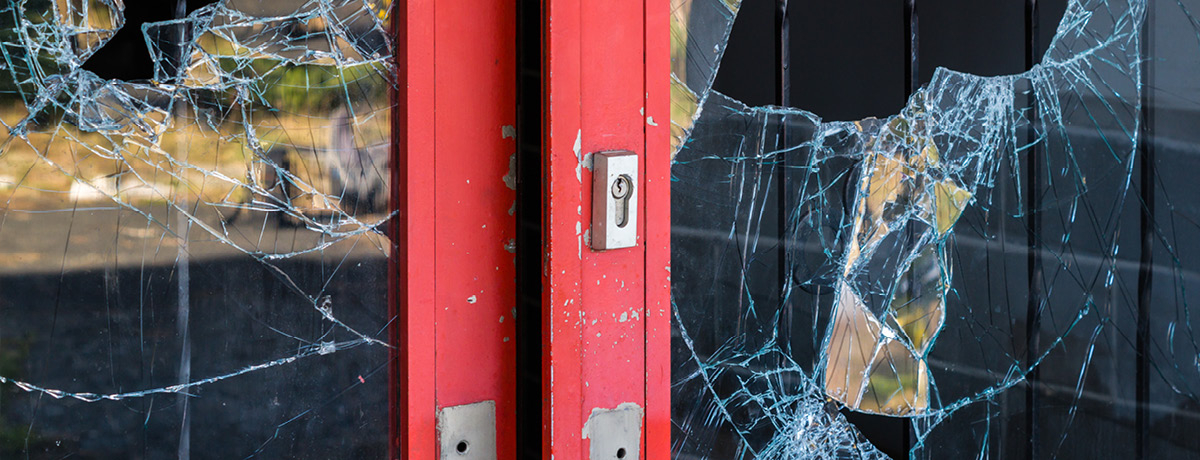 Red shop doors with glass broken open