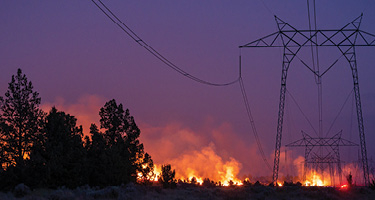 Power lines with wildfires in the backdrop