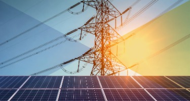 Solar panels and power lines face off with the sun shining 