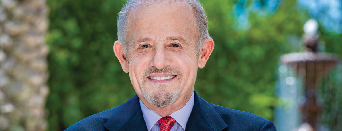 Man in blue suit with red tie standing outside