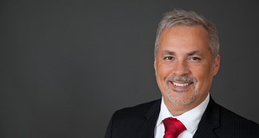 Man with grey hair and red tie