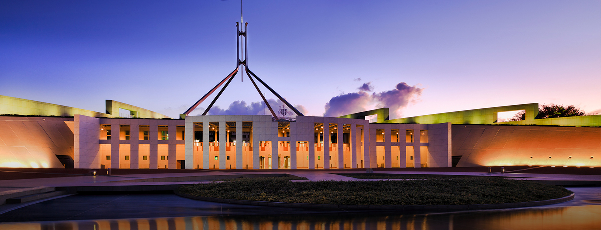 Australian Parliament beside water at sunset