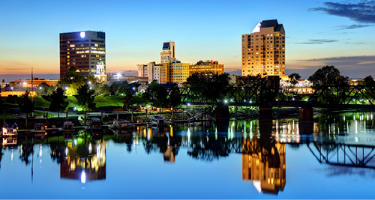 Skyscrapers against evening sky with water