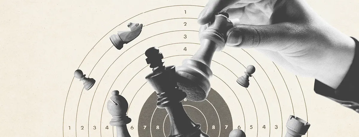A black and white photo of a hand moving a chess piece over a circular target.