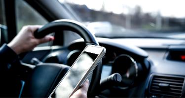 Woman driving her car distracted by her cellphone