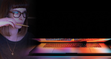 Closed laptop with woman holding pencil