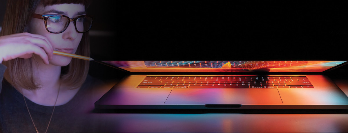 Closed laptop with woman holding pencil