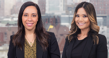 Two female lawyers wearing black suits