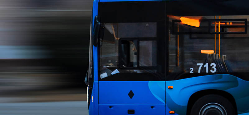 Blue bus speeding down the road with blurred wind 