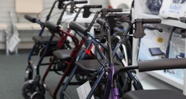 Multiple mobility walkers displayed in a medical supply store.