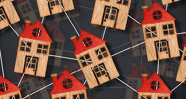 Wooden model houses connected together representing homeowners associations