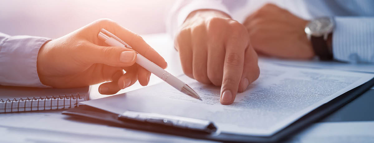 Two hands point to text on document