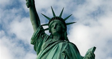 Green Statue of Liberty with a cloudy sky 