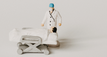 Small clay figures showing a doctor treating a patient in bed