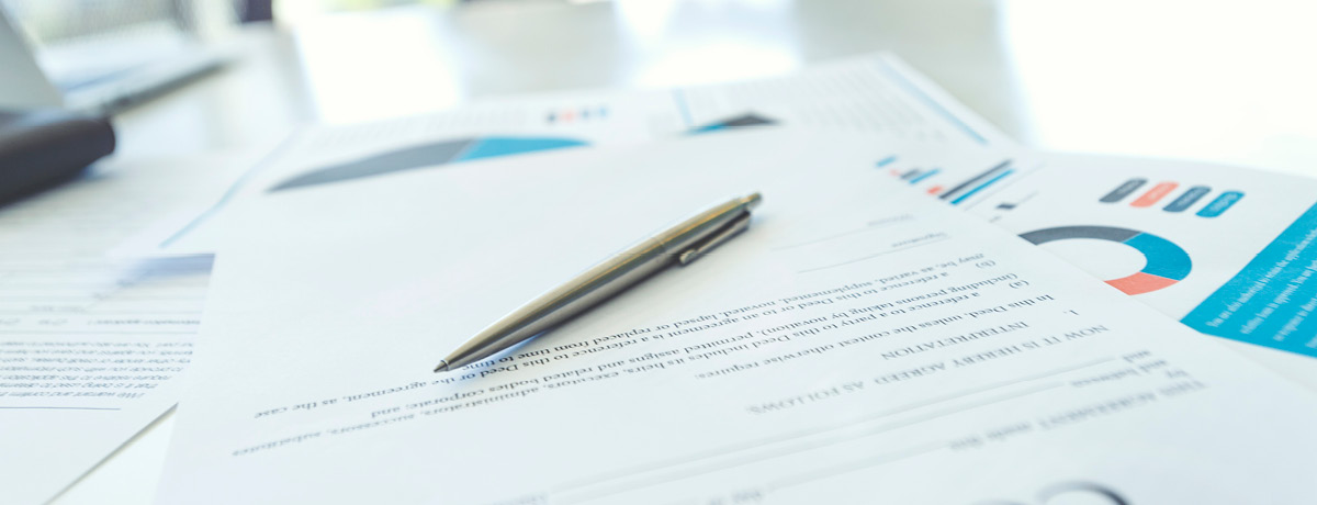 Close-up of legal documents on a desk with lawyers blurred in the background