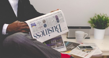 A man in a suit reading a business newspaper