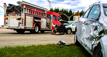 Red fire truck beside two crashed cars