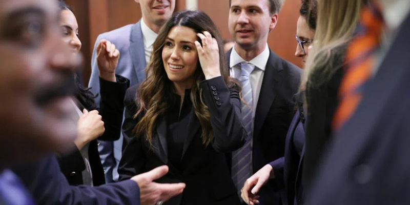 Woman standing in crowd in courtroom